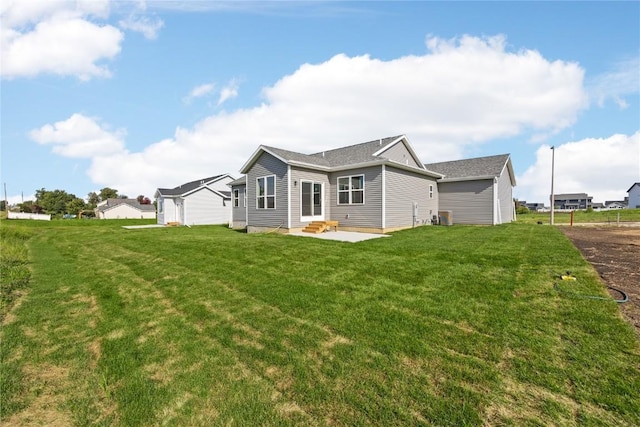 rear view of house with entry steps, a patio area, central AC, and a lawn