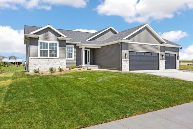 view of front of home featuring a front yard, stone siding, an attached garage, and concrete driveway