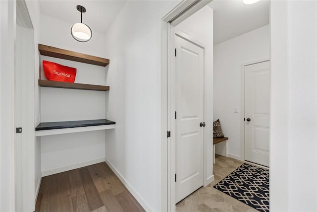 corridor with light wood-type flooring and baseboards