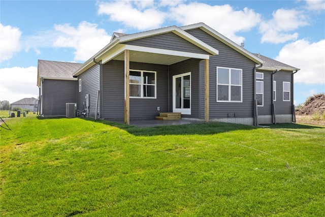 rear view of property featuring central AC unit and a yard