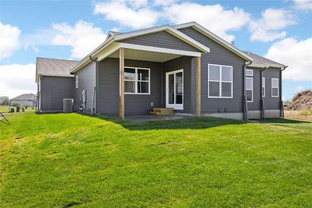 back of house with central AC unit and a lawn