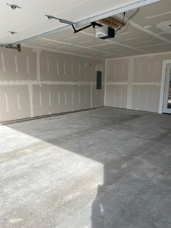 garage with electric panel and a garage door opener