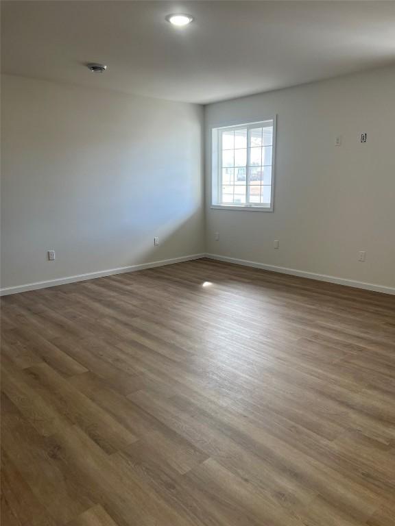 spare room featuring wood finished floors and baseboards