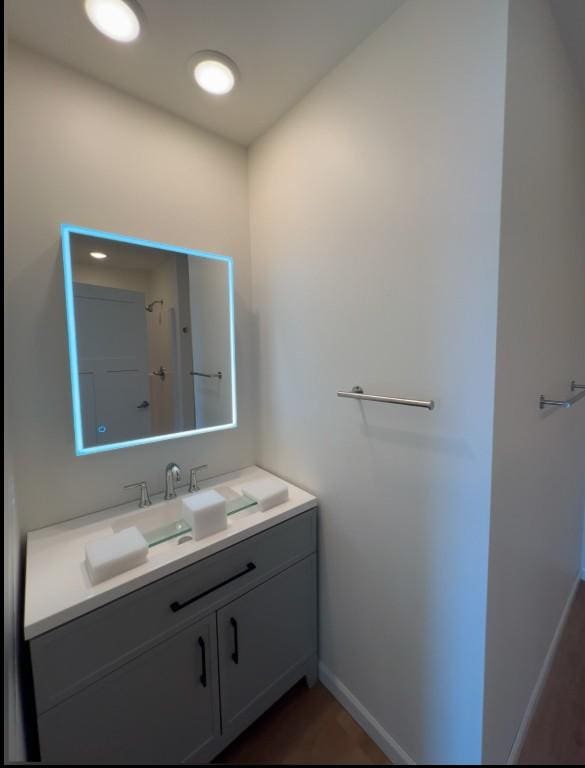 full bathroom with vanity, baseboards, and walk in shower