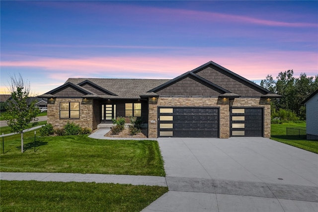 craftsman inspired home with a garage and a yard