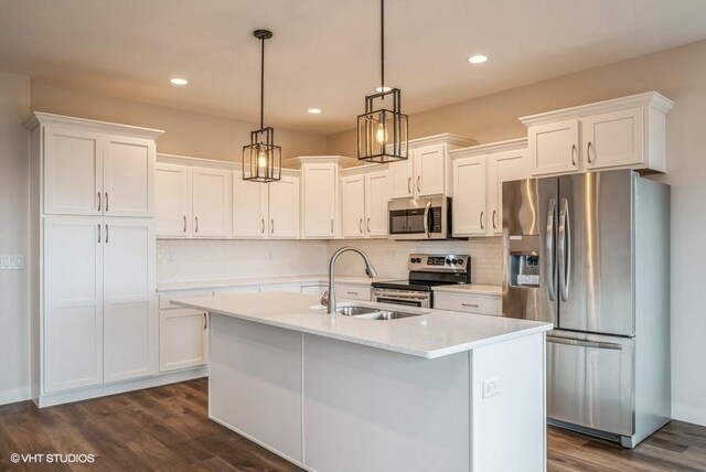 kitchen with pendant lighting, sink, white cabinetry, stainless steel appliances, and dark hardwood / wood-style floors