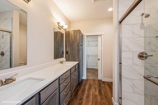 bathroom with walk in shower, vanity, and hardwood / wood-style floors