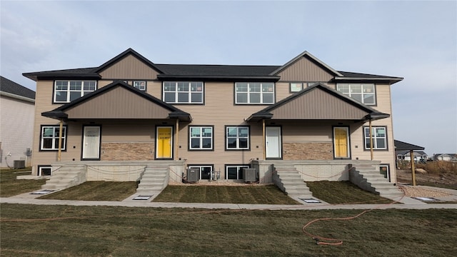 view of front of house with a front yard and central AC unit