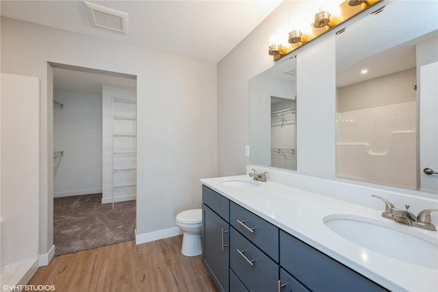 bathroom with wood-type flooring, vanity, and toilet