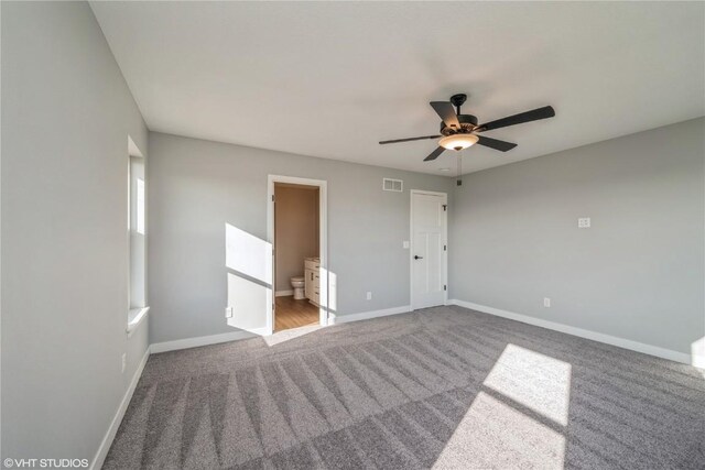 unfurnished bedroom featuring ensuite bath, carpet flooring, and ceiling fan