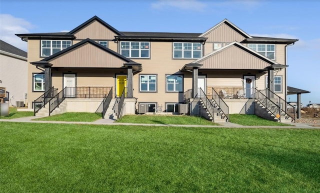 view of front of property featuring cooling unit, covered porch, and a front lawn