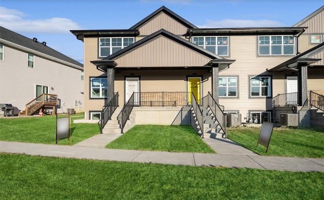 view of front of property with a front yard and central AC unit