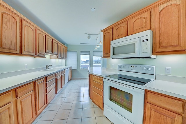 kitchen featuring white appliances, decorative light fixtures, sink, and light tile patterned floors