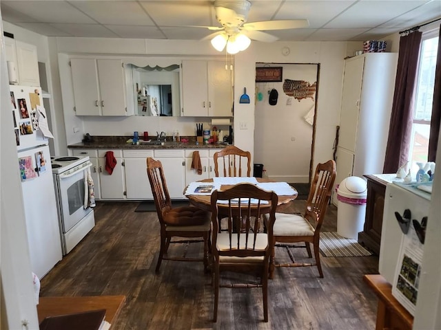 kitchen with white appliances, dark hardwood / wood-style floors, a paneled ceiling, and white cabinets