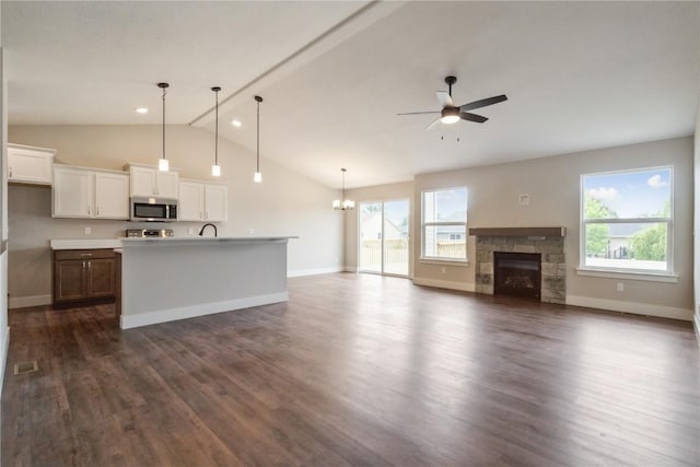 kitchen featuring dark hardwood / wood-style flooring, a center island with sink, hanging light fixtures, and plenty of natural light