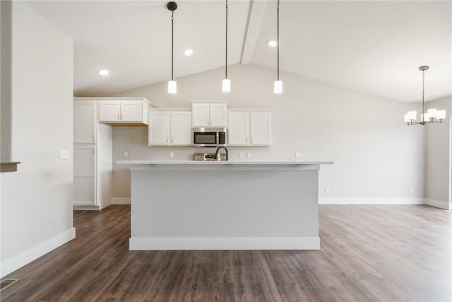 kitchen with pendant lighting, white cabinets, lofted ceiling with beams, a center island with sink, and dark hardwood / wood-style flooring