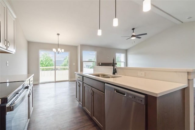 kitchen featuring pendant lighting, sink, vaulted ceiling, appliances with stainless steel finishes, and dark hardwood / wood-style flooring