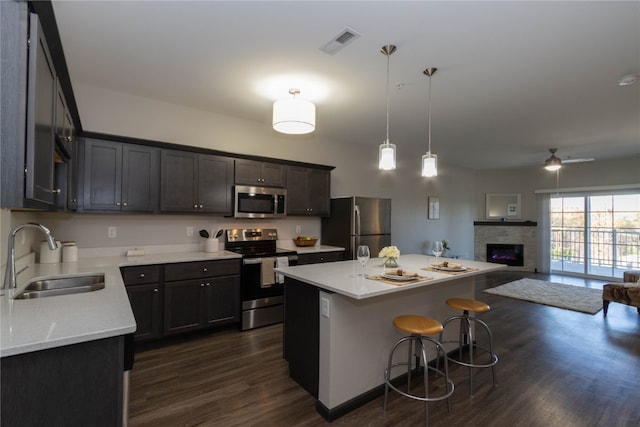 kitchen featuring sink, a center island, stainless steel appliances, dark hardwood / wood-style flooring, and pendant lighting