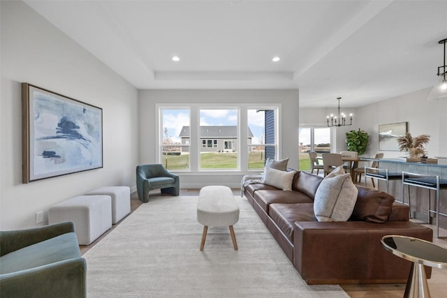 living room with a notable chandelier and a tray ceiling