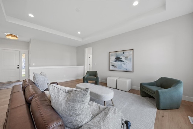 living room featuring light hardwood / wood-style flooring and a tray ceiling