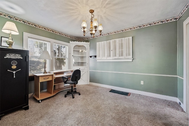 carpeted office space featuring visible vents, baseboards, and a chandelier