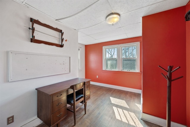 home office featuring baseboards and wood finished floors