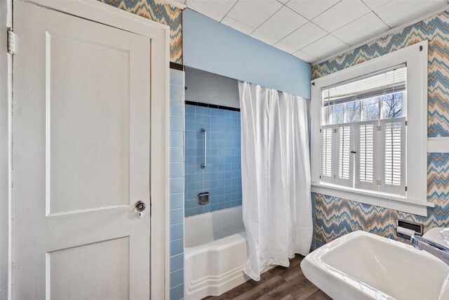 full bathroom featuring wallpapered walls, shower / tub combo, and wood finished floors