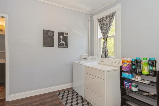 clothes washing area featuring ornamental molding, washing machine and dryer, and dark hardwood / wood-style floors