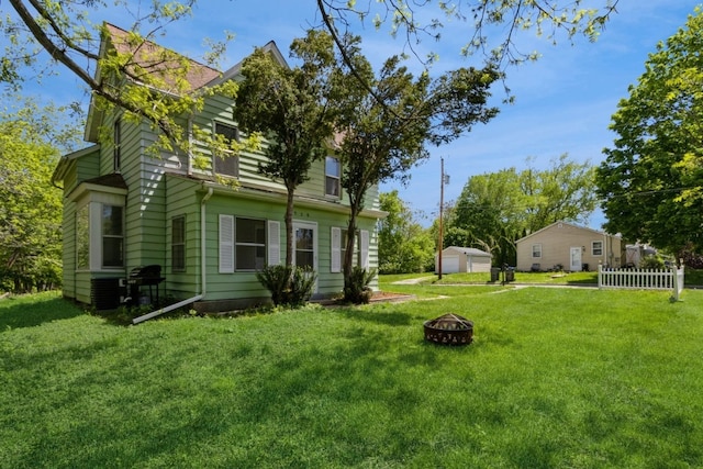 view of yard featuring central AC and an outdoor fire pit