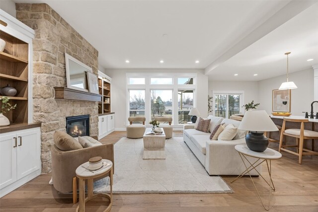 2733 Brookfield Dr, Marion, IA 52302 - living room featuring light wood-type flooring, a stone fireplace, and recessed lighting