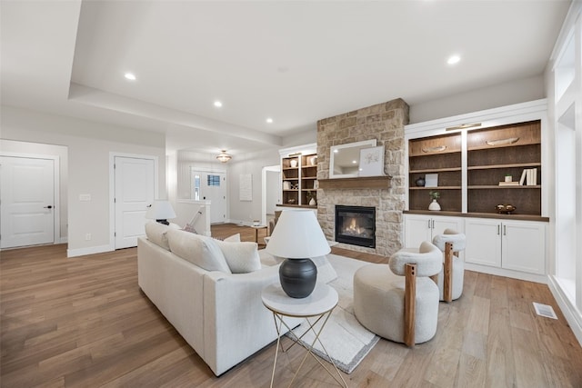 2733 Brookfield Dr, Marion, IA 52302 - living room featuring light wood-style flooring, a stone fireplace, baseboards, and recessed lighting