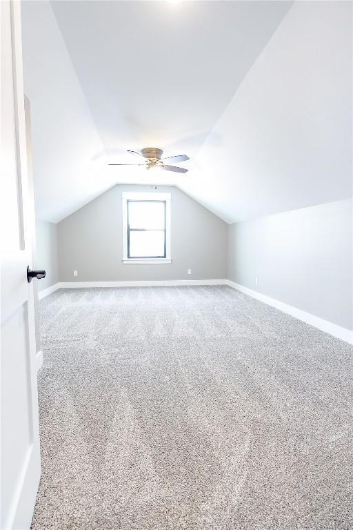 additional living space featuring carpet, ceiling fan, and lofted ceiling