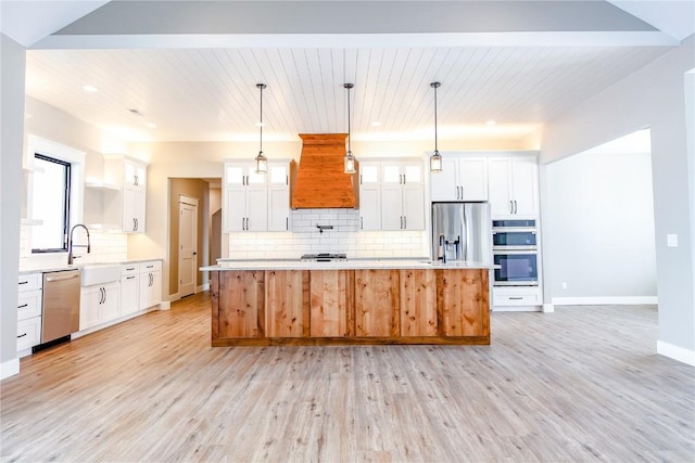 kitchen with backsplash, stainless steel appliances, white cabinets, a center island, and hanging light fixtures