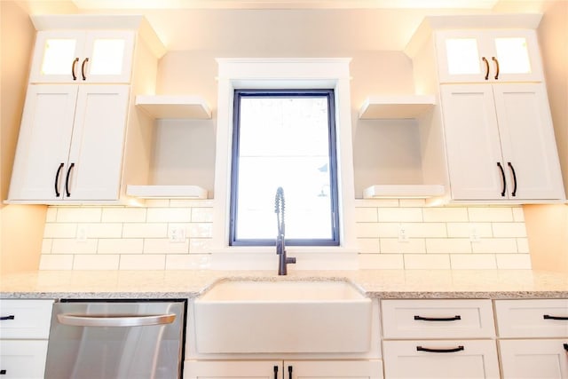 kitchen with white cabinetry, light stone counters, sink, and stainless steel dishwasher