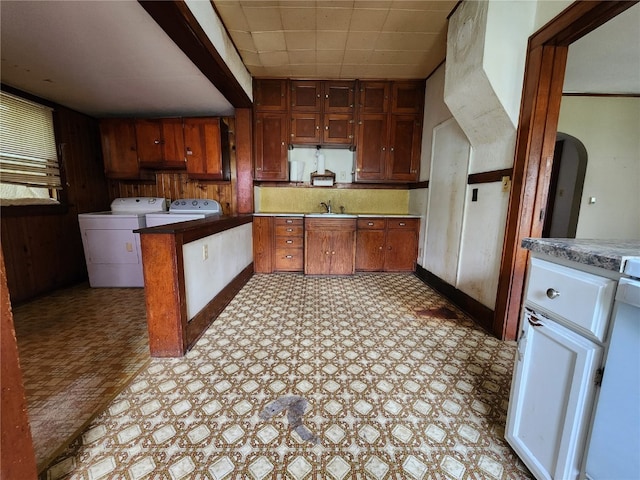 kitchen with separate washer and dryer, sink, and light tile flooring