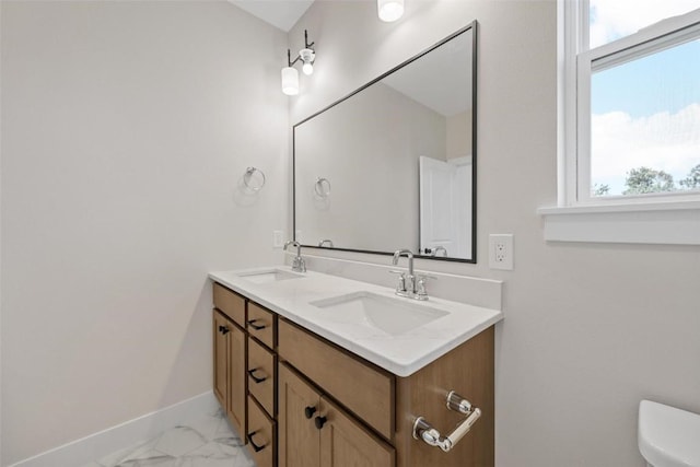 bathroom featuring toilet, a wealth of natural light, and vanity