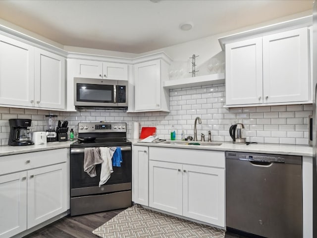 kitchen with white cabinetry, stainless steel appliances, hardwood / wood-style flooring, and sink