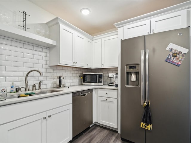 kitchen featuring white cabinets, dark wood-type flooring, appliances with stainless steel finishes, and backsplash