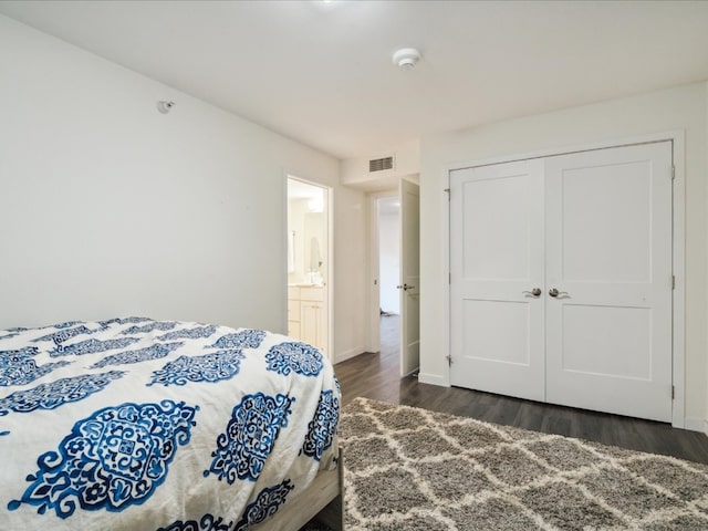 bedroom featuring dark hardwood / wood-style flooring, a closet, and ensuite bath