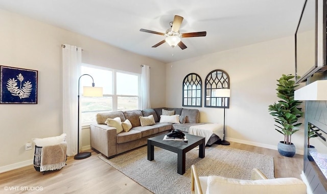 living room with light hardwood / wood-style flooring and ceiling fan