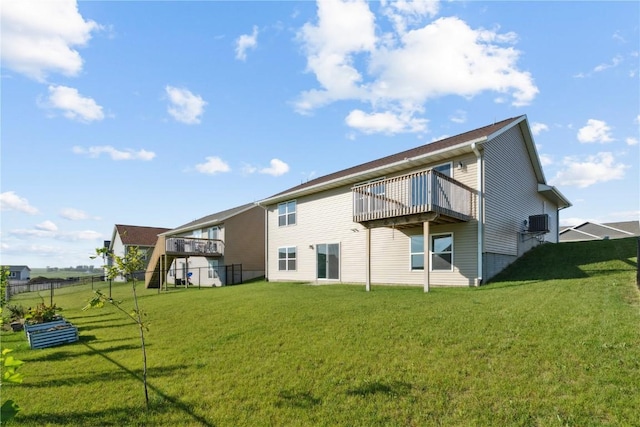 rear view of house with a lawn and a deck