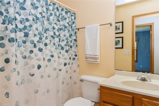 bathroom with a shower with shower curtain, vanity, and toilet