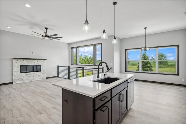 kitchen featuring stainless steel dishwasher, ceiling fan with notable chandelier, sink, and decorative light fixtures