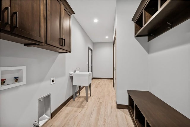 washroom with hookup for a washing machine, cabinets, light wood-type flooring, and hookup for an electric dryer