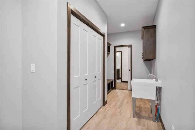 laundry area featuring light wood-type flooring