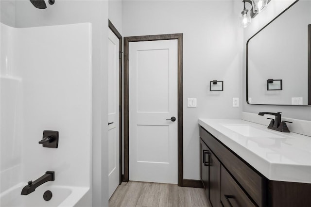 bathroom featuring vanity, wood-type flooring, and shower / washtub combination