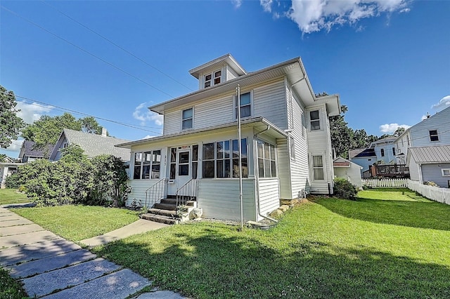 view of front of house with a sunroom and a front yard