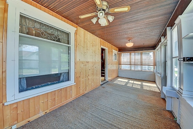 unfurnished sunroom featuring wood ceiling and ceiling fan