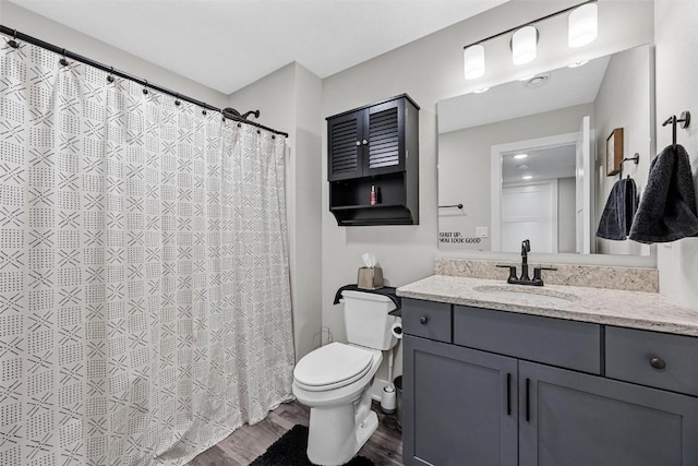 bathroom with hardwood / wood-style floors, vanity, and toilet