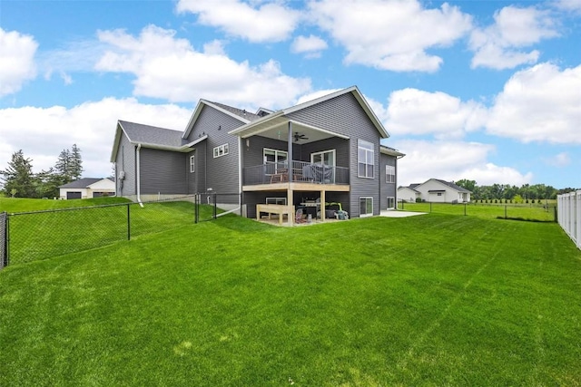 rear view of property with ceiling fan, a yard, and a wooden deck